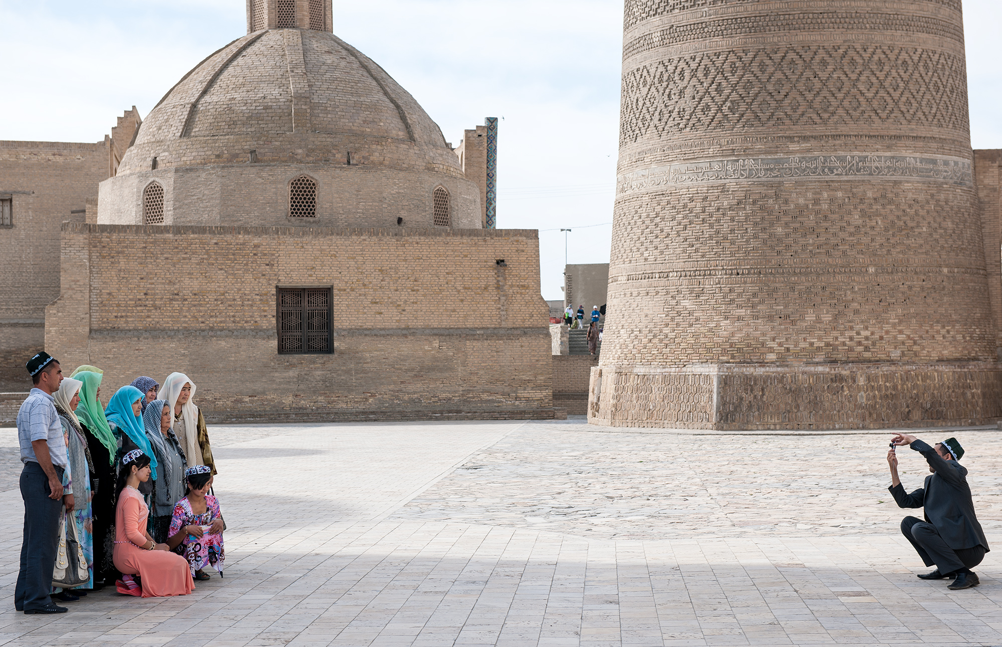 Pèlerins se prenant en photo devant le minaret Kalyan, place Po i Kalon, Boukhara.